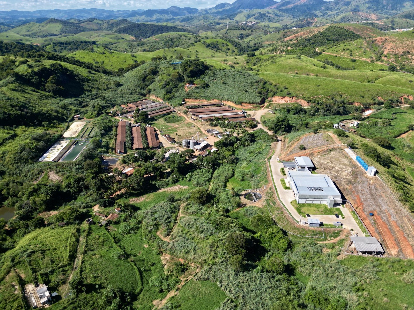 Vista aérea da fazenda do Grupo ARO entre montanhas e áreas verdes