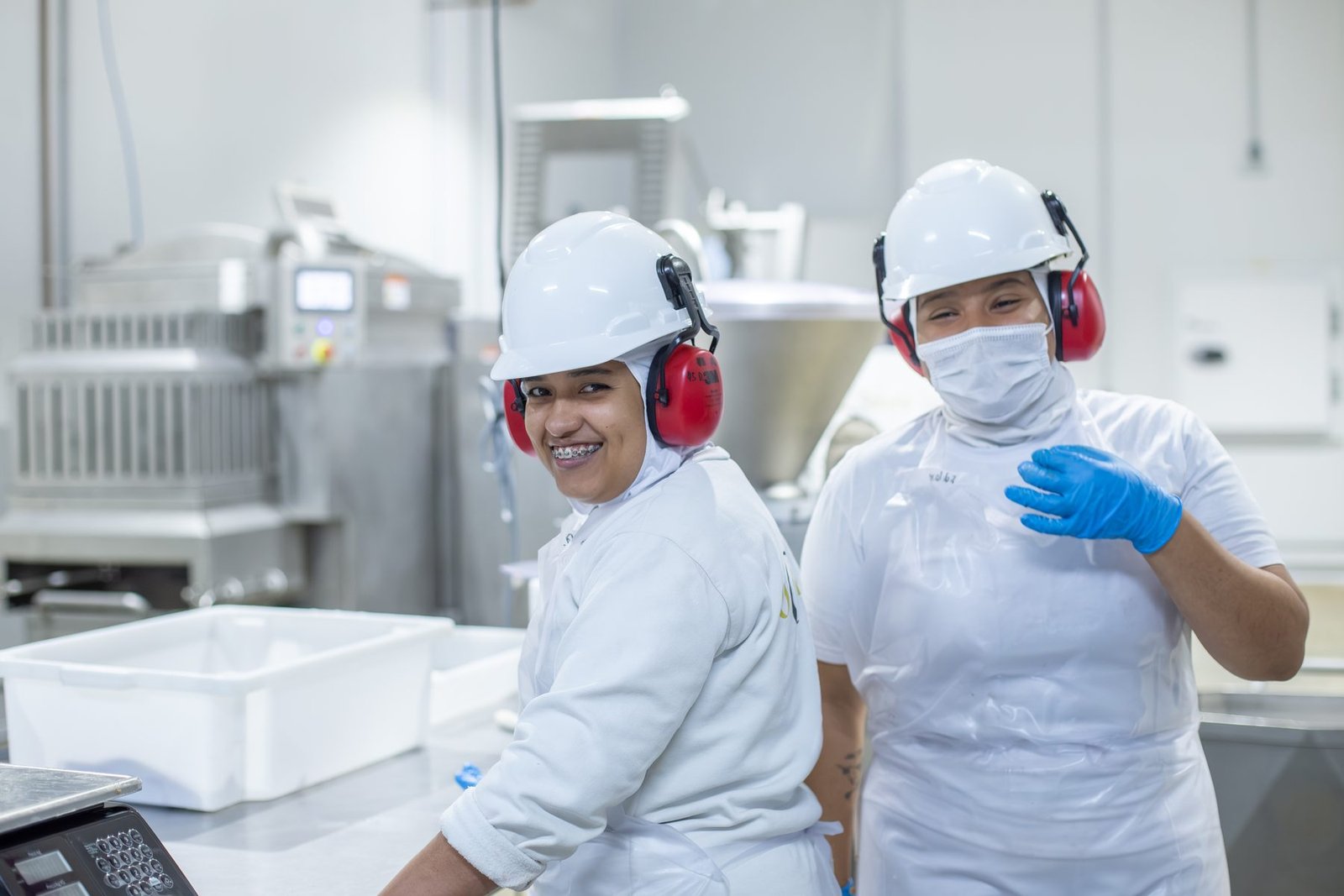 Colaboradoras do Grupo ARO sorrindo durante o trabalho na planta industrial